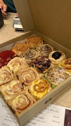 a box filled with lots of different types of pastries on top of a table