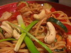 a red bowl filled with noodles and vegetables