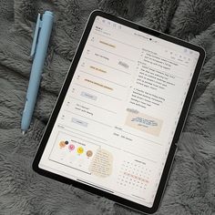 an ipad and pen sitting on a blanket