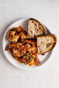 a white plate topped with shrimp and bread