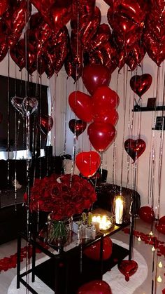 a table with red balloons and candles on it