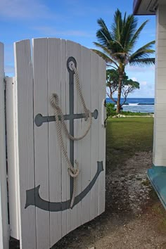 an anchor painted on the side of a wooden fence