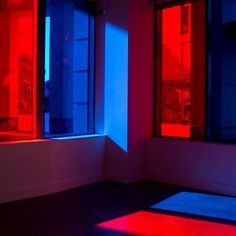 red and blue light shines through windows in an empty room