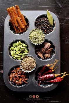 a muffin tin filled with different types of spices