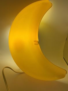 a yellow lamp sitting on top of a table next to a banana shaped light fixture