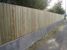 a long wooden fence next to a street