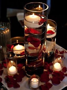 candles and rose petals in glass vases on a table