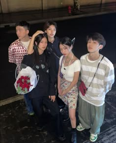 a group of young people standing next to each other on the side of a road