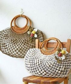 two woven purses hanging on the wall next to a wooden chair with a flower decoration