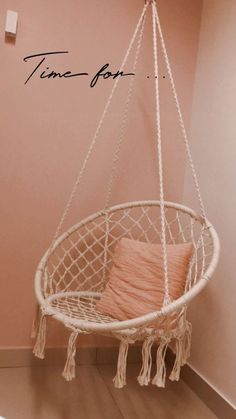 a hammock hanging from the ceiling in a room with pink walls and wood flooring