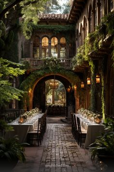 an outdoor dining area with tables, chairs and greenery on either side of the building