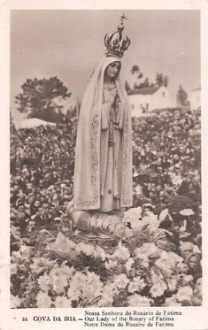 an old black and white photo of a statue in the middle of flowers with a crown on top