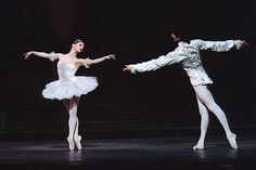 two ballerinas in white tutus are performing on stage