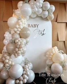 the balloon arch is decorated with white balloons and silver confetti for an elegant baby shower