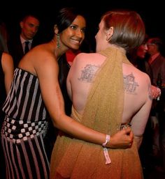 two women standing next to each other at a party