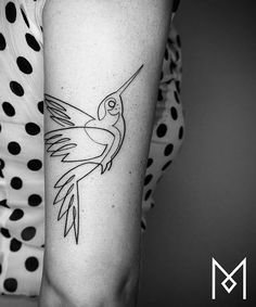 a black and white photo of a hummingbird tattoo on the right arm with dots