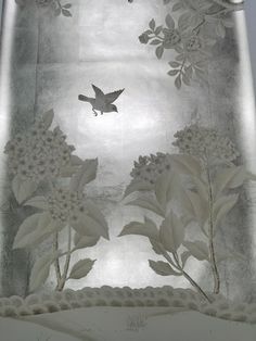 an image of a bird flying over flowers and trees in the sky on a window sill