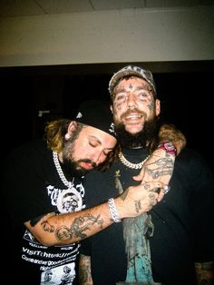 two men hugging each other with tattoos on their arms