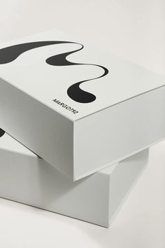 two white boxes sitting side by side on top of each other with black and white designs