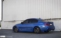 a blue car parked in front of a building