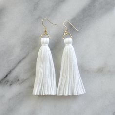 By popular demand, finally...white tassel earrings from Libby & Smee! These handmade tassel earrings will make a big style impact, whether you’re wearing them with jeans and a t-shirt or with a dress. At less than one-tenth of an ounce, Libby & Smee statement earrings feel virtually weightless!+ super lightweight cotton tassel in white+ gold-plated stainless steel ear wire hooks (lead-free and nickel-free)+ comes with plastic earring back for security+ LONG is 3.25 inches and MINI is 2.5 Bohemian White Tassel Earrings For Pierced Ears, Elegant White Tassel Earrings For Pierced Ears, Elegant White Fringe Earrings, White Tassel Dangle Earrings, White Bohemian Tassel Earrings For Gift, Bohemian White Tassel Earrings For Gift, Bohemian White Tassel Earrings As Gift, White Fringe Tassel Earrings As Gift, White Tassel Earrings With Latkans As Gift