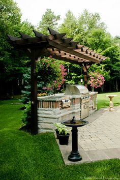 an outdoor bbq and grill in the middle of a yard