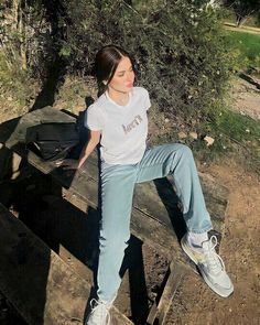 a woman is sitting on a wooden bench