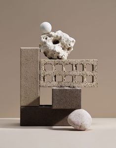 an object made out of cement blocks and rocks on top of each other with one rock in the middle