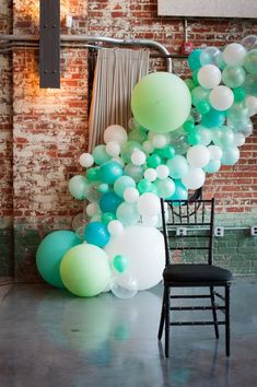 a chair sitting next to a bunch of balloons