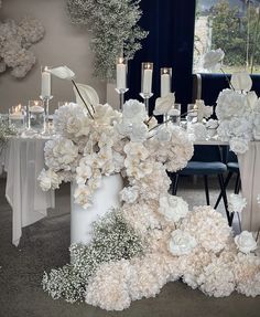 a table topped with white flowers and candles