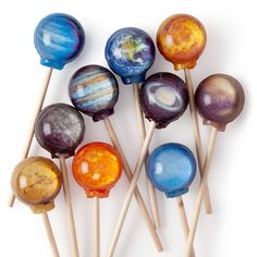 an assortment of planets on wooden sticks against a white background