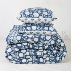 three blue and white pillows stacked on top of each other