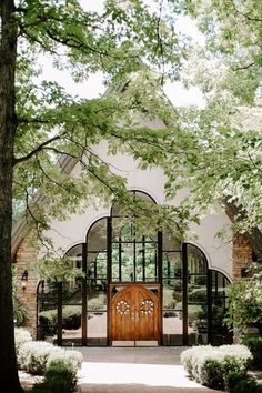 a large wooden door sitting in the middle of a lush green forest