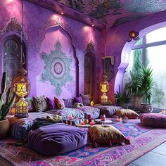 a room with purple walls and lots of pillows on the floor in front of a large window