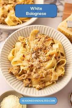 two plates filled with pasta and sauce on top of a table next to breadcrumbs