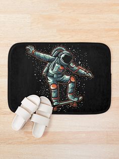 an astronaut skateboarding in space on a black bath mat next to white slippers