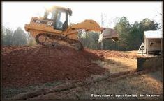 a bulldozer is parked on top of a pile of dirt