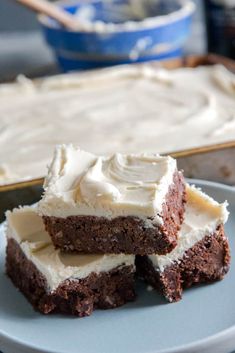 three pieces of cake sitting on top of a plate next to a pan filled with frosting