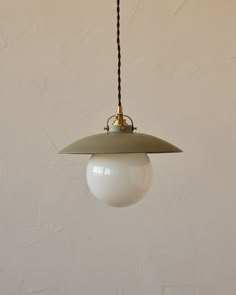 a white light hanging from a brown cord