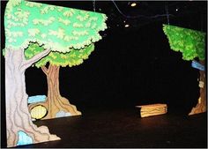 the stage is decorated with trees and benches for children to sit on or play in