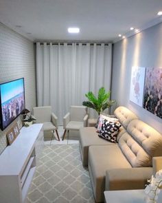 a living room filled with furniture and a flat screen tv sitting on top of a wall