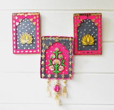 three colorful wall hangings with flowers on them