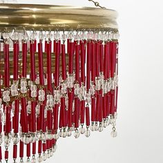 a chandelier hanging from the ceiling with red and clear bead trims