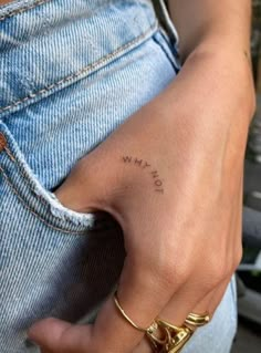 a person with a small tattoo on their left hand and the word love is written in cursive writing