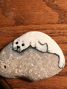 a rock painted with an image of a polar bear laying on it's side