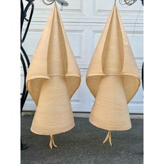 two lamps made out of cardboard sitting next to each other on the ground in front of a garage door