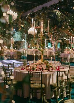 the tables are set up for an event with chandeliers hanging from the ceiling