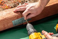 a person using a power drill to attach a piece of wood