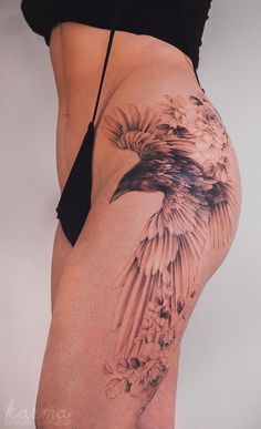 a woman's thigh with a bird tattoo on it