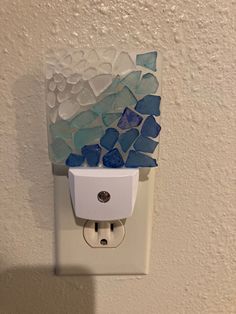 a light switch cover with sea glass on it